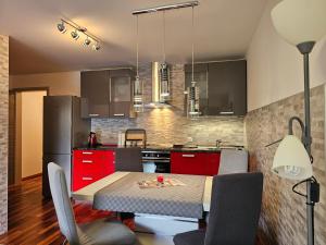 a kitchen with red cabinets and a table with chairs at Sončna vila Bovec, Studio A&B in Bovec