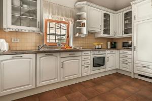 a white kitchen with white cabinets and a window at Rustic Villa Lavanda - Pool & Garden - Happy Rentals in Šmarje
