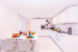 a white kitchen with a table and chairs at Yellow View Apartment - Ronco S Ascona - Happy Rentals in Ronco sopra Ascona