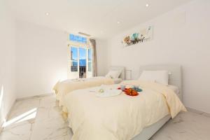 two beds in a white bedroom with a table on it at Yellow View Apartment - Ronco S Ascona - Happy Rentals in Ronco sopra Ascona