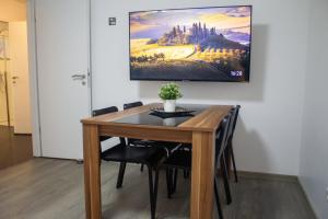 a dining room table with chairs and a painting on the wall at Logement Moderne in Mundolsheim