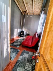 a red couch in a room with a fireplace at Casa kumey in Puerto Varas