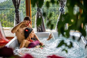 a man and a woman sitting in a hot tub at Casa Favo de Mel - Jacuzzi & Piscina - Refúgio na Montanha in Arcos de Valdevez