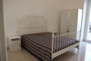 a white bedroom with a bed and a dresser at Villa Adriano in Salve