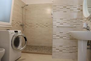 a bathroom with a washing machine and a sink at Villa Adriano in Salve