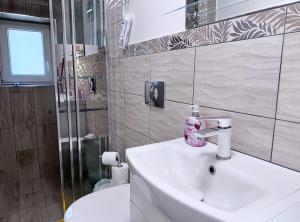 a bathroom with a white sink and a toilet at Apartament pod Osówką in Głuszyca +18 photos