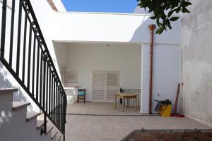 a patio with a table and a stair case at Villa Adriano in Salve