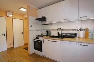 a kitchen with white cabinets and a sink at Apartament pod Osówką in Głuszyca