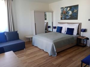a bedroom with a bed and a blue couch at Palomino pokoje agroturystyka in Świnoujście