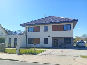 a large white house with a parking lot at Palomino pokoje agroturystyka in Świnoujście