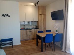 a kitchen and dining room with a table and blue chairs at Palomino pokoje agroturystyka in Świnoujście