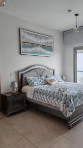 a bedroom with a bed and a table with a picture on the wall at Playa Escondida in María Chiquita