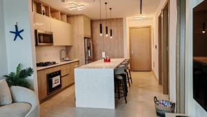 a kitchen with a white island in a room at Playa Escondida in María Chiquita