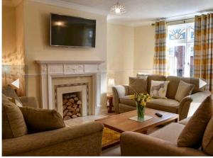 a living room with a fireplace and a tv on the wall at Annie Place in Whitby