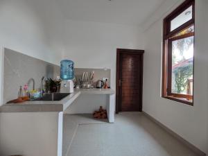 a white kitchen with a sink and a window at Casa Luna Home Stay in Dickwella +39 photos