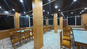 a restaurant on a cruise ship with tables and chairs at Harsil River Retreat in Harsil