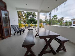 a wooden table and chairs on a patio at Casa Luna Home Stay in Dickwella
