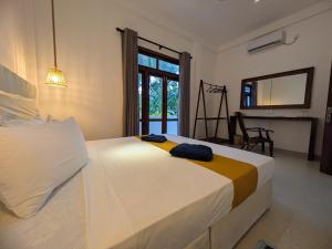 a bedroom with a large white bed and a fireplace at Casa Luna Home Stay in Dickwella