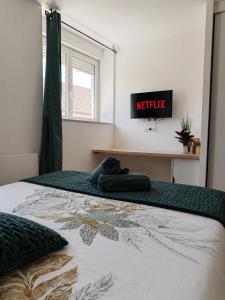 a bedroom with a bed with ametix sign on the wall at Les Fontaines in Besançon +45 photos