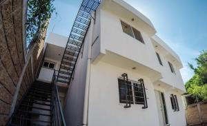 eine Treppe, die zu einem weißen Haus hinaufführt in der Unterkunft Departamento con estacionamiento cerca de SixFlags Dorados e IMSS in Oaxtepec