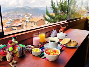 a table with breakfast food and a view of a city at Mirador All Sur Cusco in Cusco