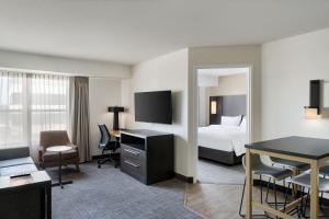 a hotel room with a bed and a desk at Residence Inn Merrillville in Merrillville +30 photos