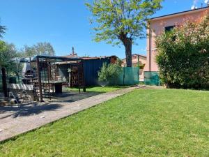 a yard with a playground and a house at Casa con giardino in Cecina
