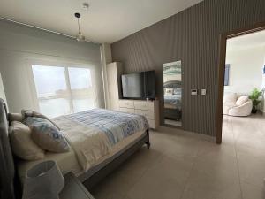 a bedroom with a bed and a flat screen tv at Playa Escondida in María Chiquita