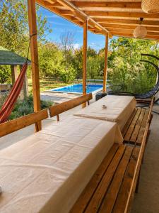 a bedroom with two beds and a hammock next to a pool at Casa Bella Fruška Gora with HOT TUB in Velika Remeta