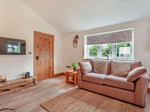 a living room with a couch and a window at 1 Bed in Shepton Mallet oc-94296 in Pilton