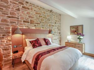 a bedroom with a bed with a brick wall at 1 Bed in Shepton Mallet oc-94296 in Pilton