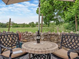 a table with a bottle of wine and two chairs at 1 Bed in Shepton Mallet oc-94296 in Pilton