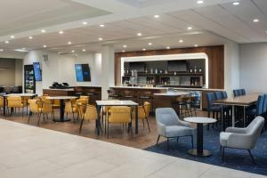 a restaurant with tables and chairs and a bar at Courtyard by Marriott across Universal Orlando in Orlando