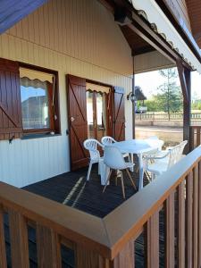 a deck with a table and chairs on a house at Chalet Rivage Home in Pont-de-Poitte