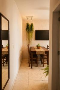 a dining room with a table and chairs and a mirror at Refúgio com Varanda, Wi-Fi Rápido, 450m da Praia, seu Cantinho em BC in Balneário Camboriú