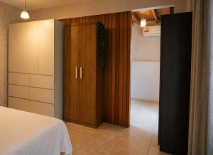 a room with a closet and a bed and a door at Refúgio com Varanda, Wi-Fi Rápido, 450m da Praia, seu Cantinho em BC in Balneário Camboriú