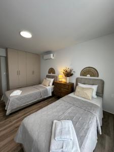 a bedroom with two beds and a table in it at Oleana Cosy Studio in Lampi