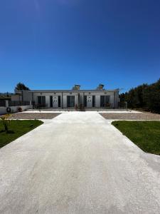 an empty driveway leading to a large white building at Oleana Cosy Studio in Lampi