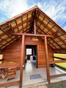 a large wooden building with a large roof at Chalés Champion Capitolio in Capitólio
