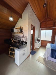 a kitchen with a stove and a sink in a room at Chalés Champion Capitolio in Capitólio