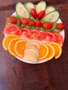 a plate of vegetables and fruit on a wooden table at Atlas Green Lodge in Imlil