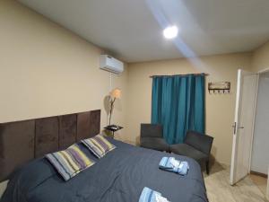 a bedroom with a bed and a chair at Hospedaje Gabriel in Yapeyú
