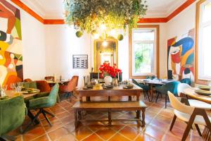 a restaurant with tables and chairs and a chandelier at Domaine La Cournonsécoise in Cournonsec