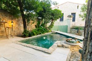 a small swimming pool in a yard with a house at Domaine La Cournonsécoise in Cournonsec