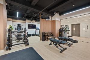 a gym with several treadmills and weights in a room at 17John Residences in New York
