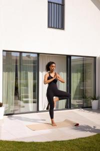 a woman doing a yoga pose in front of a house at Villa Flora in Colares