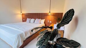 a bedroom with a bed and a potted plant at Villa Monarca in Ayampe