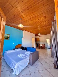 a large bed in a room with a wooden ceiling at Albatros rooms in Vathi