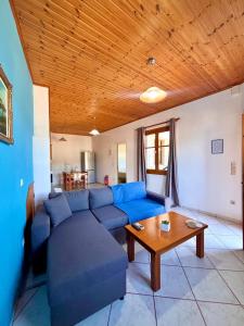 a living room with a blue couch and a wooden ceiling at Albatros rooms in Vathi