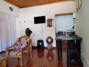 a living room with a table and a television on the wall at Casa Sol y Alegría in Honda
